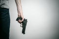 Horror and firearms topic: suicide with a gun on a gray background in the studio Royalty Free Stock Photo
