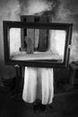 Horror girl in creepy old interior holding mirror