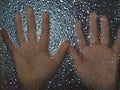 Horror hands. The shadow hands of human behind the glass. Corrugated textured glass through which children`s palms are visible Royalty Free Stock Photo