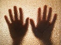 Horror hands. The shadow hands of human behind the glass. Corrugated textured glass through which children`s palms are visible Royalty Free Stock Photo