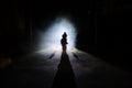 Horror scene of a scary children's ghost, Silhouette of scary baby doll on dark foggy background with light Royalty Free Stock Photo