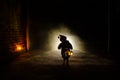 Horror scene of a scary children's ghost, Silhouette of scary baby doll on dark foggy background with light