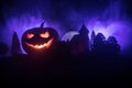 Horror view of Halloween pumpkin with scary smiling face. Head jack lantern with spooky building