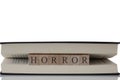 Horror written on wooden blocks inside a book isolated on a white background