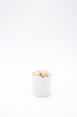 Snack time and appetizer concept - organic rosted pistachios in a white bowl on a white surface Royalty Free Stock Photo
