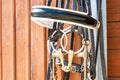 Horse bridle hanging on stable wooden door. Closeup outdoors.