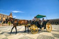 Horse carriage tourists strolling through the Plaza of Spain in Seville