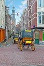 Horse carts through the narrow streets in Amsterdam Netherlands