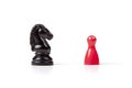 Horse chess game piece and a small red game piece facing each other, diversity, conflict, dialog. Different tabletop games concept Royalty Free Stock Photo