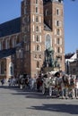 Horse-drawn carriage in front of medieval gothic St. Mary\'s Basilica at Main market square, Krakow, Poland