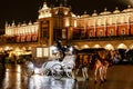 Horse-drawn carriage in front of Sukiennice Cloth Hall in Krakow, Poland
