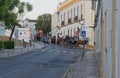 A Horse driven black Carriage wends its way through the narrow streets of Estoi along with Riders of all ages.