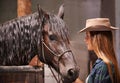 Horse, farm and ranch owner with woman in barn or stable for work in agriculture or sustainability. Cowgirl, texas or Royalty Free Stock Photo