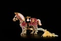 Horse figurine souvenir keychain in gold color ornate with bright pebbles shot on a dark background