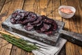 Horse game meat cured sausage with rosemary on a cutting board. Wooden background. Top view Royalty Free Stock Photo