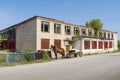 A horse harnessed to a cart near an abandoned building of the House of Culture in a Russian village