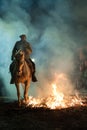 Horse with its rider rapidly breaking through the fire