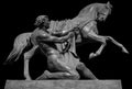 Horse and man ancient sculpture of Anichkov Bridge in Saint Petersburg. Monument isolated on black background Royalty Free Stock Photo