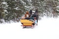 A horse pulls a sleigh with people along a snow-covered road of a winter pine forest. Retro transport carries tourists to the Royalty Free Stock Photo