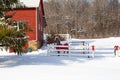 Horse standing near a red barn in the snow Royalty Free Stock Photo