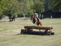 Horse rider jumping over a barrier