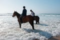 Horse riding at the beach at the ocean Royalty Free Stock Photo