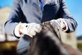 Sportsman wearing blue gloves getting ready for horse riding Royalty Free Stock Photo