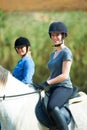 Horse riding is safe when you respect the animal. Portrait of two women sitting on their horses outside. Royalty Free Stock Photo