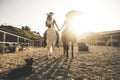 Horse riding scenic picture with two animal and people couple and a dog taking hands with love and friendship and sunset sunlight Royalty Free Stock Photo