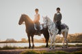 Horse riding, sunset and hobby with friends in nature on horseback by the lake during a summer morning. Countryside Royalty Free Stock Photo