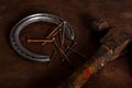 A horse shoe, rusted nails and an old hammer on a dark brown leather .