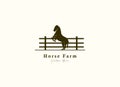 Horse silhouette behind wooden fence paddock for vintage retro rustic countryside western country farm ranch logo design Royalty Free Stock Photo