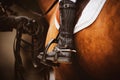 The horse is wearing horse ammunition - a stirrup, a brown old saddle, a white saddlecloth, a bridle, and a rider in boots is Royalty Free Stock Photo