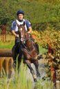 Horseback jumping in splashes water