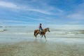 Horseman in cowboy dress are jojjing on sandy beach at Khao Takiab Hua Hin in Thailand Royalty Free Stock Photo