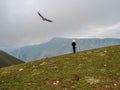 Horseman in a white cap and a flying eagle on the background of high mountains. Dagestan Royalty Free Stock Photo