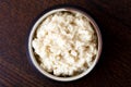 Horseradish sauce in rustic pottery bowl from above on dark wood Royalty Free Stock Photo