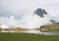 Horses in the Ayous Lakes with the Midi dOssau mountain in the clouds, Pyrenees National Park.