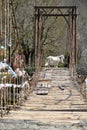 Horses on the bridge over the river in the mountains. tourist horseback riding. the male groom transfers the horses across the bri Royalty Free Stock Photo