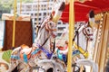 Horses on a carnival Merry Go Round. Old French carousel in a holiday park. Big roundabout at fair in amusement park. Royalty Free Stock Photo