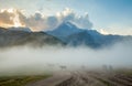 Horses into fog and mount Kazbek on the background