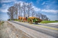 4 Horses Pulling an Antique Amish Manure Spreader so Farmer can Fertilize the Field on a Blue Sky Day