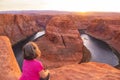 Horseshoe Bend on the Colorado River near Page, woman tourist looking at beautiful sunset view, Arizona, USA Royalty Free Stock Photo