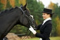 Horsewoman jockey in uniform with horse