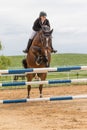 Horsewoman is jumping over the hurdle. Vertically.