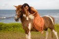 Horsewoman lying on the withers of the horse. Asian woman riding horse. Homan and animal concept. Bali