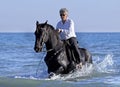 Horsewoman in the sea Royalty Free Stock Photo