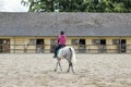 Horsewoman training on the white hors at the court
