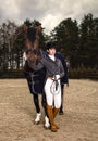 Horsewoman in uniform with a brown horse outdoor. Royalty Free Stock Photo