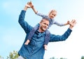 Horsing around with Dad. a happy dad carrying his young daughter on his shoulders.